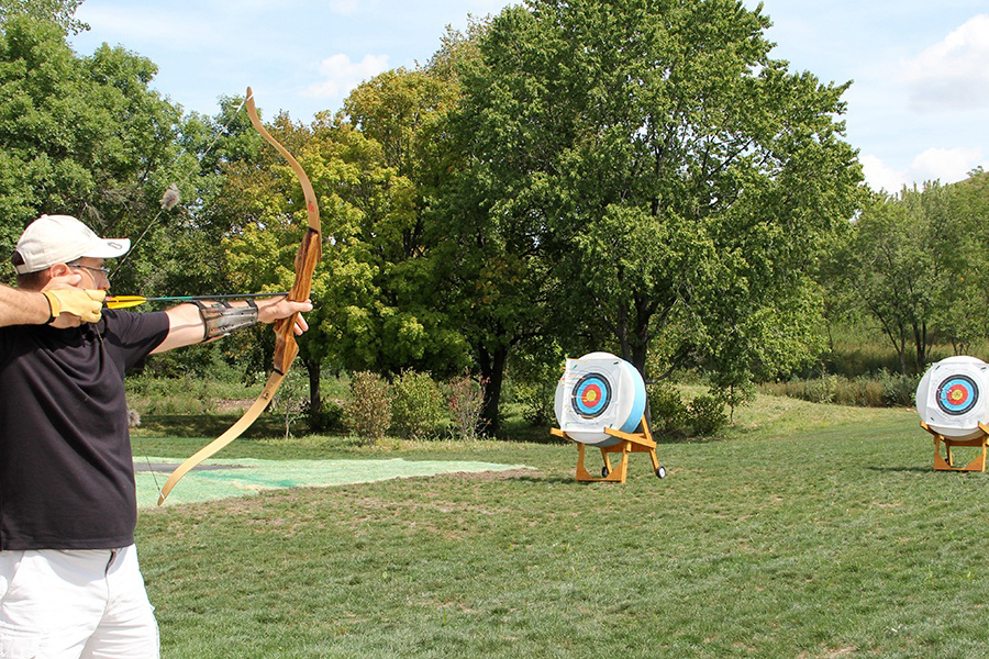 man shooting a bow and arrow at a target man shooting a bow and arrow at a target